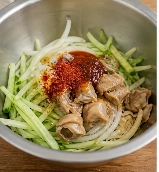 골뱅이 무침 | 비빔면 기본 소스으로 맛있게 만드는 법 조리 단계 5 이미지 - 넓은 볼에 손질한 오이, 양파, 대파, 썰어둔 골뱅이를 넣고 비빔면 액체